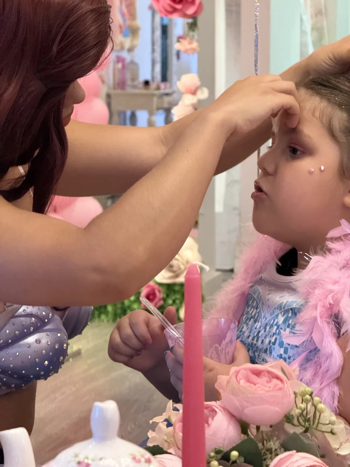 Ariel princess character applying face gems on little girl at girls spa birthday party in South Florida