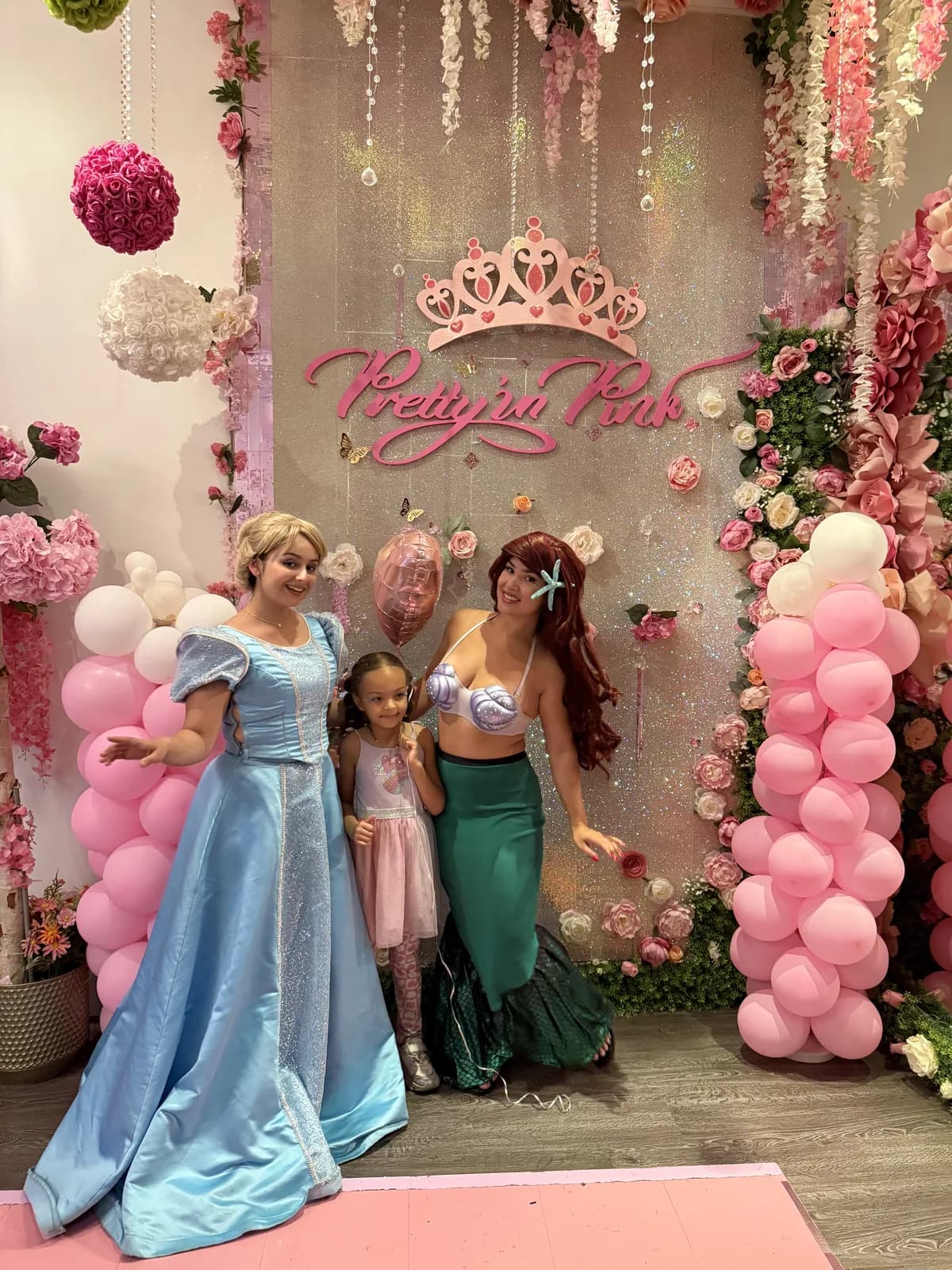 Birthday girl posing with Disney princess characters Cinderella and Ariel at Pretty in Pink Princess Spa Fort Lauderdale